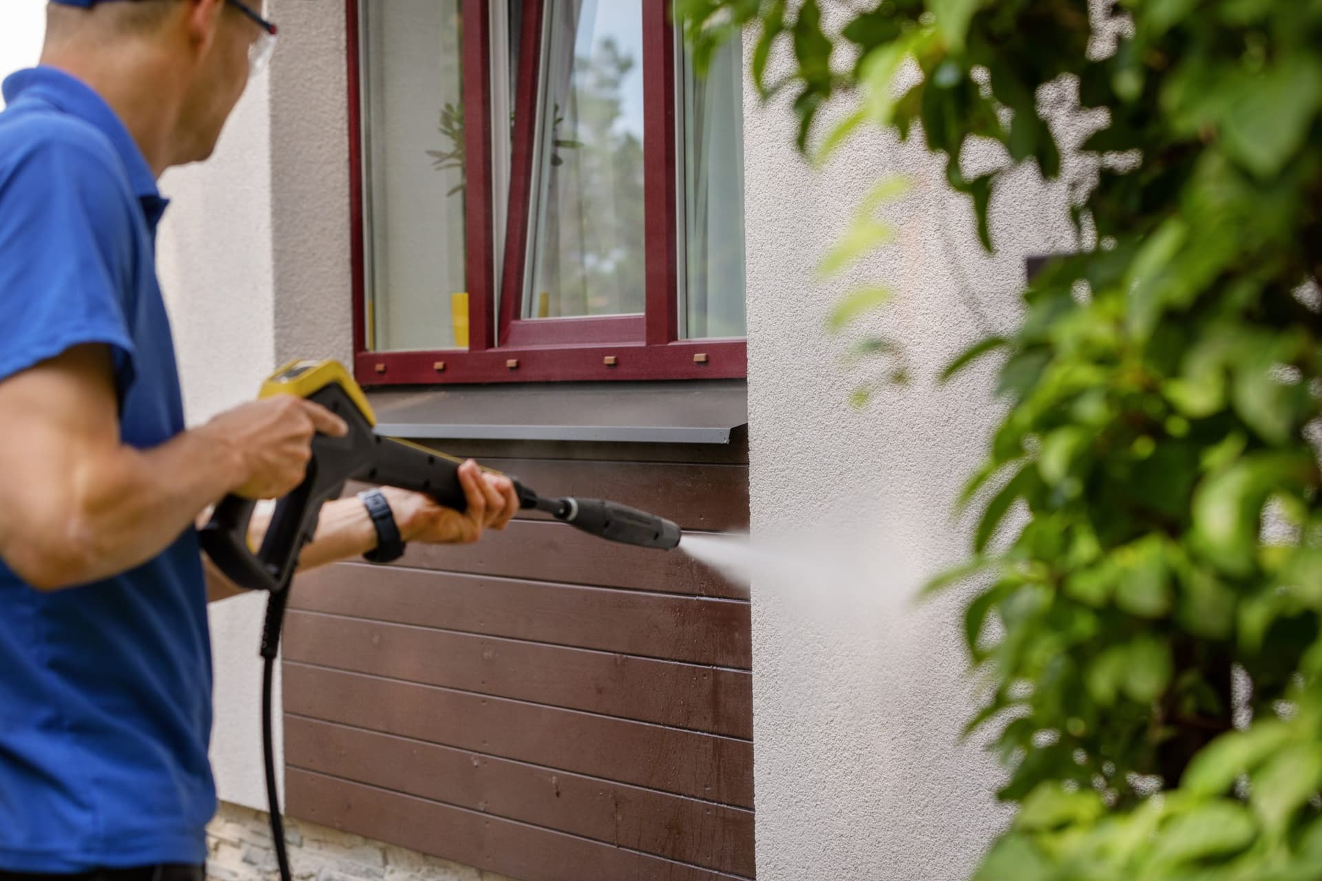 Texas Best technician power washing the exterior of a home