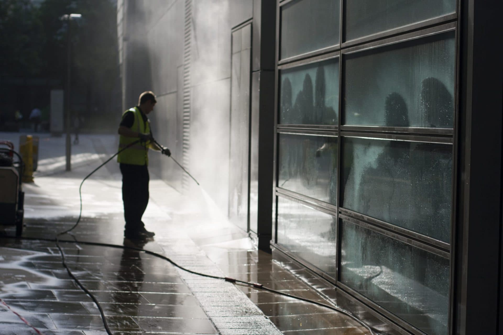 Technician power washing a commercial exterior