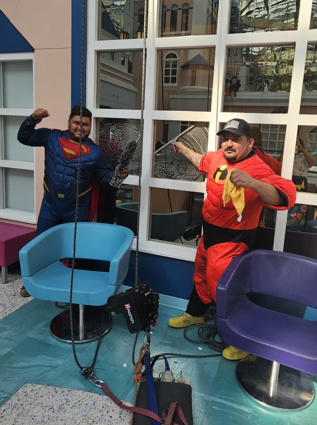 Texas Best technicians dressed as superheroes cleaning the atrium glass at Cook Children's Hospital
